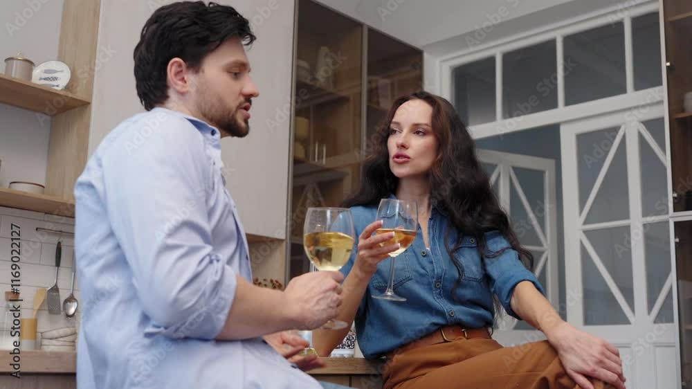Couple enjoying drinks and conversation in a cozy kitchen during evening Couple enjoying drinks and conversation in a cozy kitchen during evening