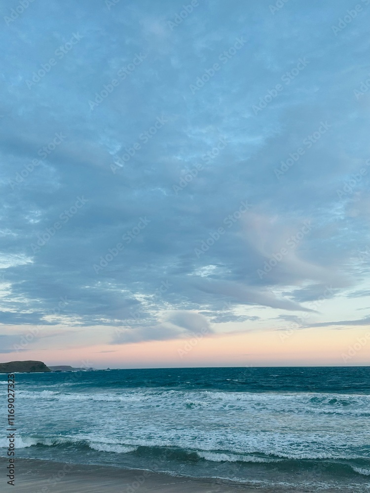 Obraz premium Sunset on Phillip Island near Melbourne, Australia. Watching the sunset over the ocean from the beach waiting for the penguins to arrive as the waves roll into shore
