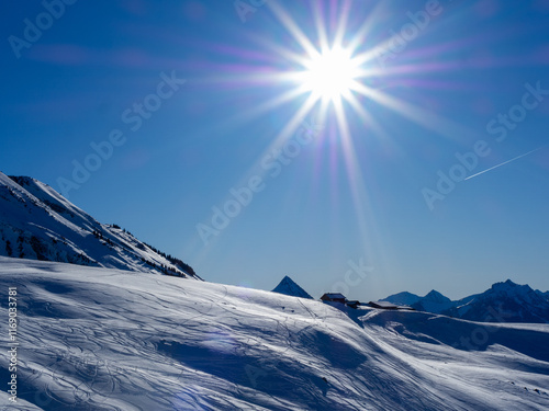 Bright Sunlit Mountain Landscape with Powder Snow Tracks photo