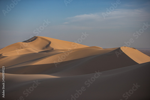 Khongor Sand Dunes in the Gobi Desert of Mongolia. Vast golden sand dunes stretching across the desert landscape, surrounded by mountains and showcasing the unique beauty of one of Mongolia’s most ico