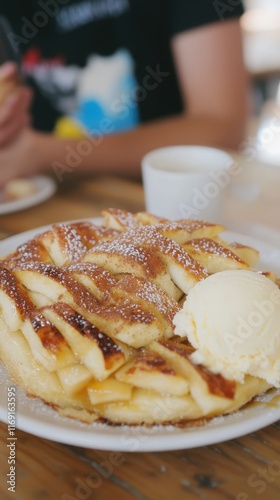 A macro shot of a warm apple pie slice, its golden lattice crust filled with cinnamon-spiced apples. The pie is served with a scoop of vanilla ice cream and a drizzle of caramel sauce on a white  photo