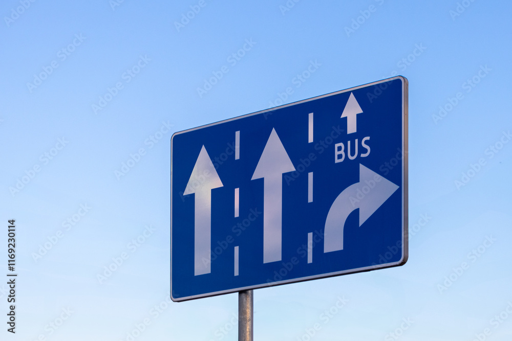 traffic sign with lane directions for cars and buses, featuring arrows and a bus lane symbol against a clear blue sky traffic sign with lane directions for cars and buses, featuring arrows and a bus lane symbol against a clear blue sky