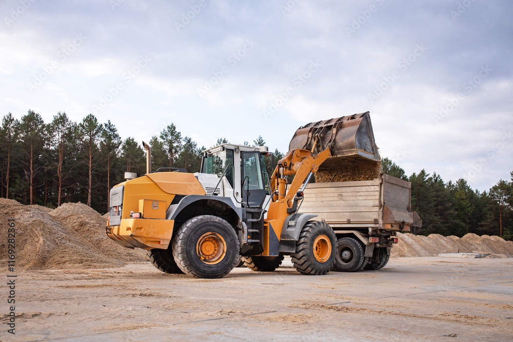 Wheel front loader or bulldozer at a construction site in a quarry. Powerful modern equipment for earthworks. Construction site. Wheel front loader or bulldozer at a construction site in a quarry. Powerful modern equipment for earthworks. Construction site.