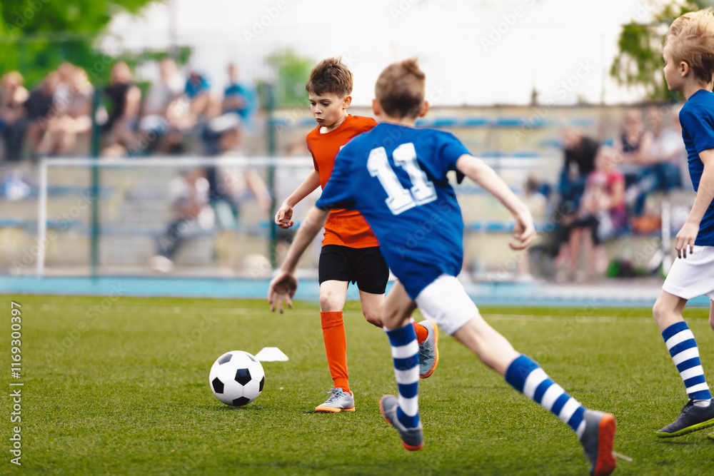 Children playing football. Kids play soccer on an outdoor pitch. Little boys kicking a ball in the stadium. Football junior league. Healthy activity for young children. School sports club team Children playing football. Kids play soccer on an outdoor pitch. Little boys kicking a ball in the stadium. Football junior league. Healthy activity for young children. School sports club team