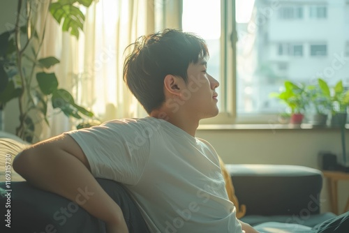 Asian man having a backache at the living room, no face. Free Download Asian man having a backache at the living room, no face. - GFXLoad