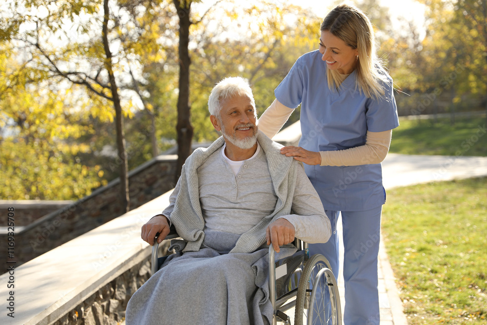 Caregiver assisting senior man on wheelchair in park. Home health care service Caregiver assisting senior man on wheelchair in park. Home health care service
