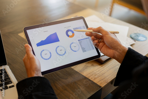 close up on businesman manager hand using stylus pen for writing or comment on screen dashboard tablet photo