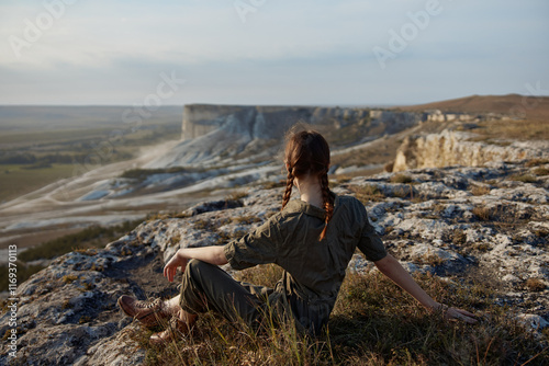 Woman contemplating majestic beauty of valley and mountains during journey of selfdiscovery and adventure