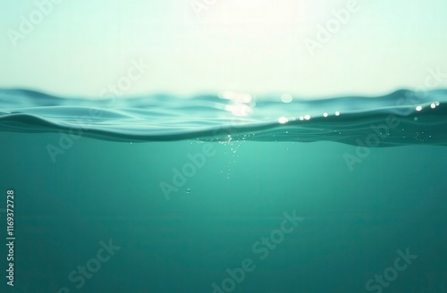 Half underwater view showing surface of turquoise sea with sun reflections photo