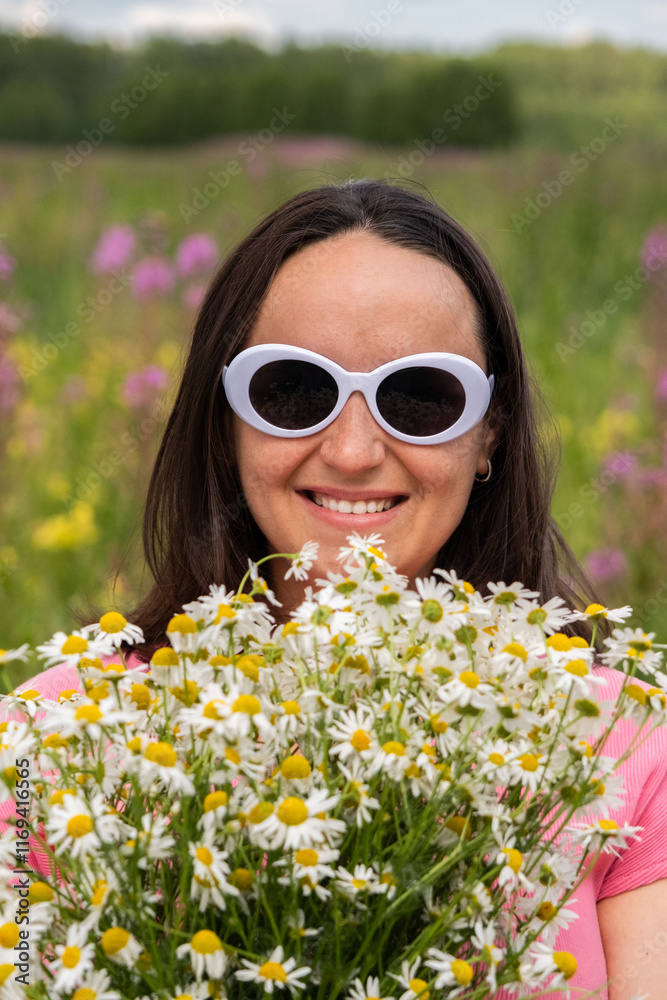 A joyful young woman wears white sunglasses while holding a fragrant bouquet of daisies, surrounded by a vibrant field of blooming flowers on a sunny day. A joyful young woman wears white sunglasses while holding a fragrant bouquet of daisies, surrounded by a vibrant field of blooming flowers on a sunny day.