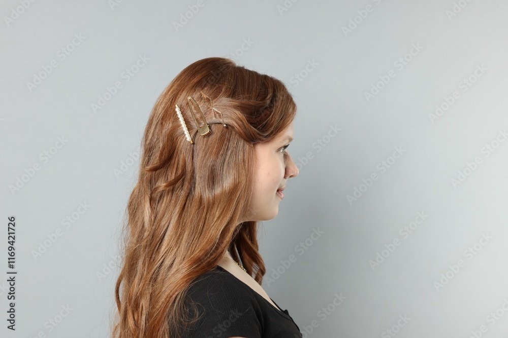 Teenage girl with stylish hair clips on light grey background. Space for text Teenage girl with stylish hair clips on light grey background. Space for text