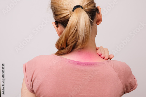 Woman rubbing sore neck. Back view of unrecognizable woman touching and massaging her neck. Joint pain. Woman has neck problems.