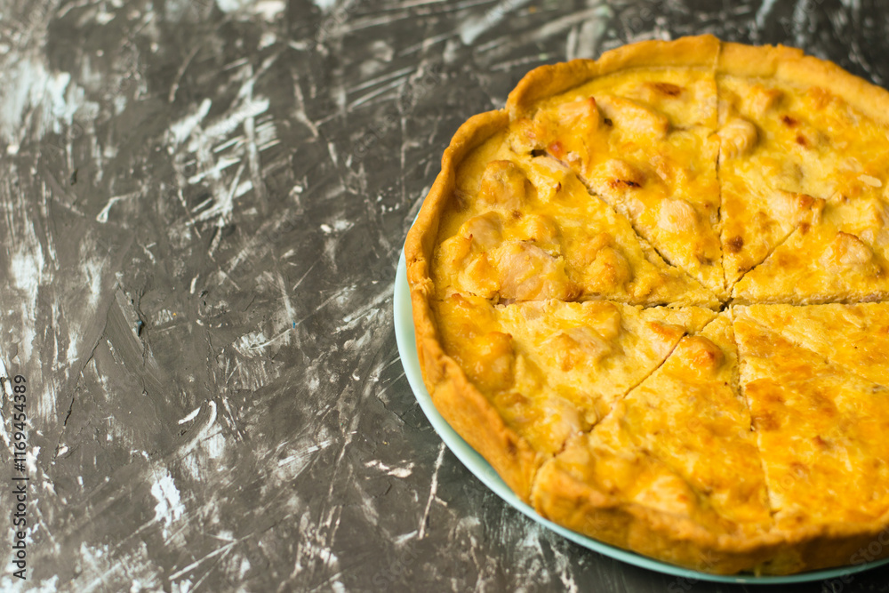 Delicious French quiche pie with chicken and cheese cut into pieces, on a dark background with place for text, copy space. Food blog concept, writing recipes Delicious French quiche pie with chicken and cheese cut into pieces, on a dark background with place for text, copy space. Food blog concept, writing recipes