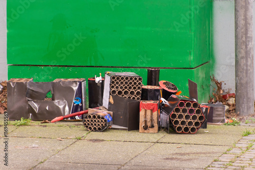Burnt used batteries of fireworks after Sylvester are scattered on city streets. Concept of pollution of environment of ban and danger of firecrackers, protection of animals from noise of explosions.