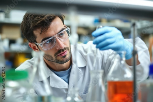 Scientist preparing to add clear liquid from a Florence flask in a lab photo