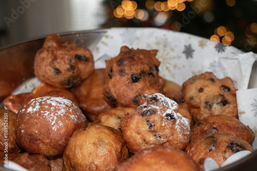 Oliebol fresh Dutch pastry in bowl with Christmas tree background. New years treat in the Netherlands. Happy New Year snack. photo