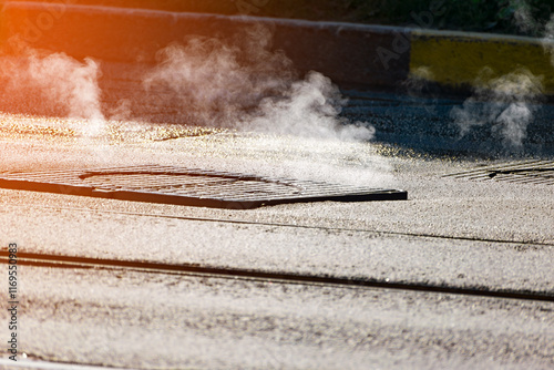 hot steam from a road manhole. asphalt. close-up