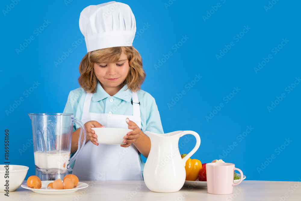Child chef dressed cook baker apron and chef hat isolated on studio background. Healthy nutrition kids food. Child chef dressed cook baker apron and chef hat isolated on studio background. Healthy nutrition kids food.