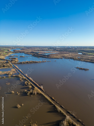 Aerial drone view of flooding from heavy rainfall causes road closures as nearby Fairburn Ings nature reserve floods in West Yorkshire. Agricultural fields and local businesses flooded.