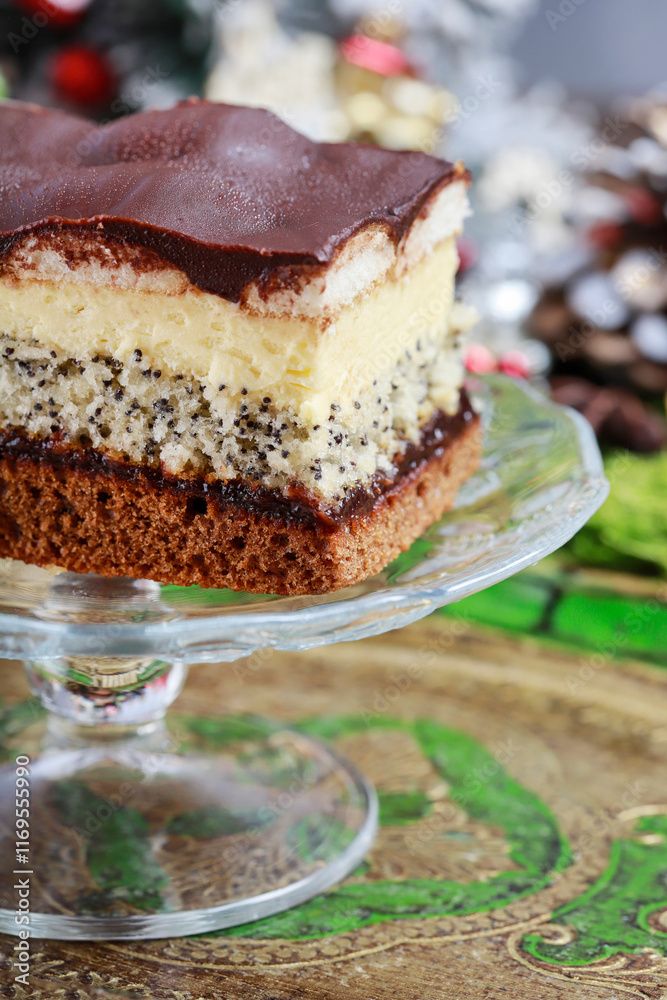 Multi layer cake with vanilla, poppy seed and chocolate among Christmas decorations.