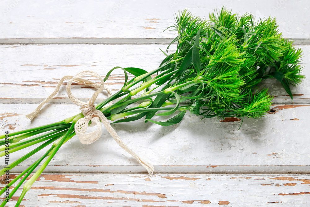 Green branches on a rustic wooden table.
