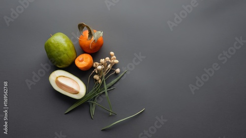 Minimalist food arrangement with fresh fruits on a dark gray background