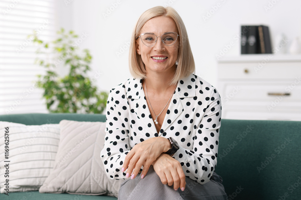 Portrait of smiling middle aged woman on sofa at home Portrait of smiling middle aged woman on sofa at home