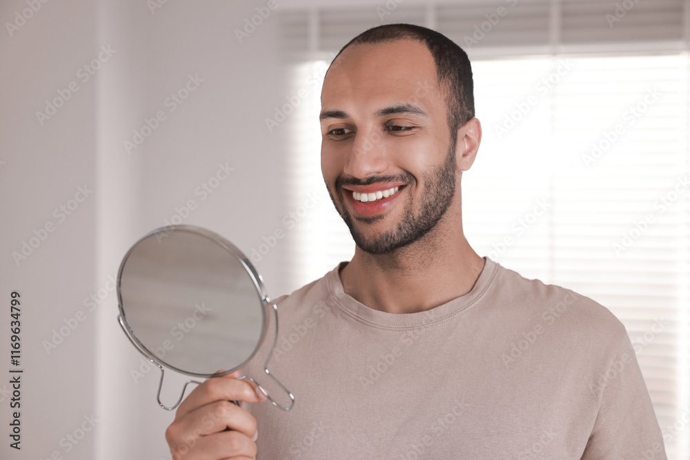 Smiling man looking at mirror in room Smiling man looking at mirror in room