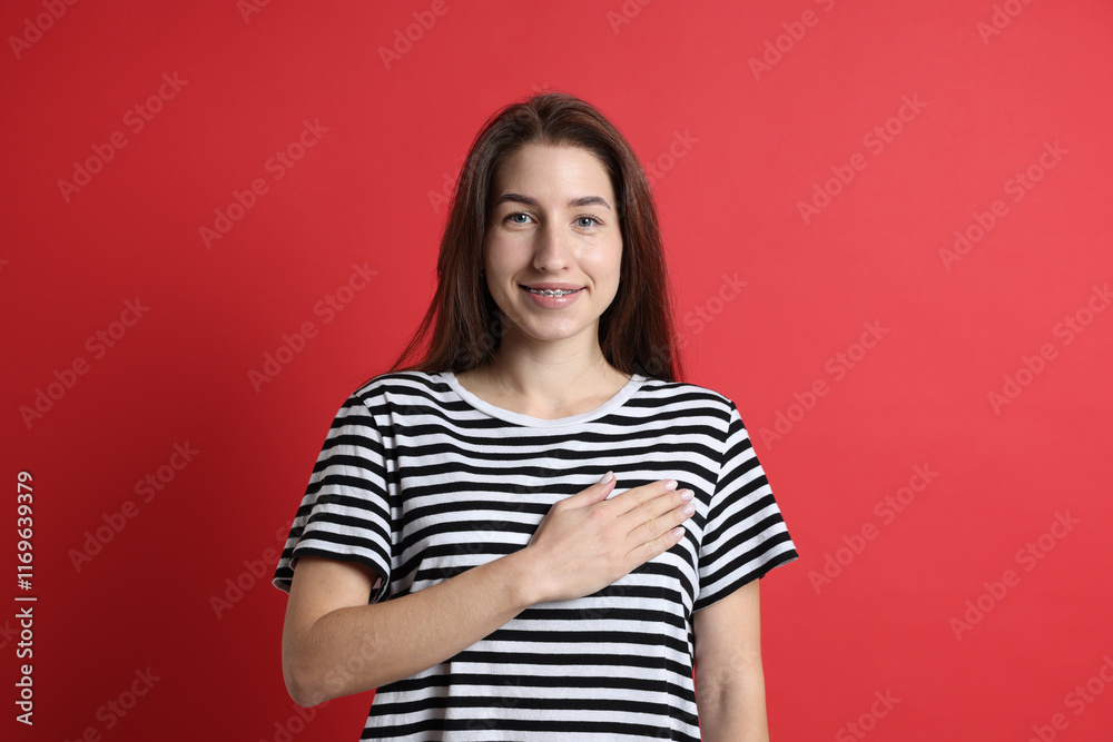 Woman making promise on red background. Oath gesture