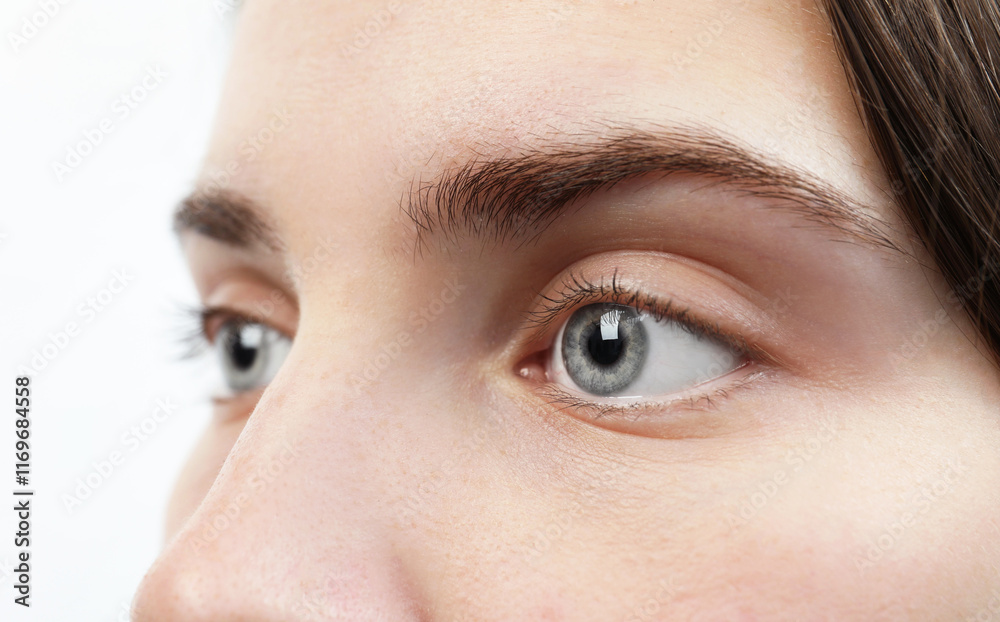 Naklejka premium Closeup view of young woman with beautiful blue eyes on white background