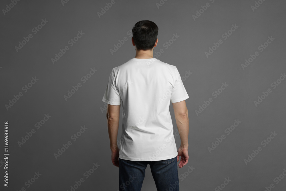Man in blank white t-shirt on grey background, back view. Mockup for design Man in blank white t-shirt on grey background, back view. Mockup for design