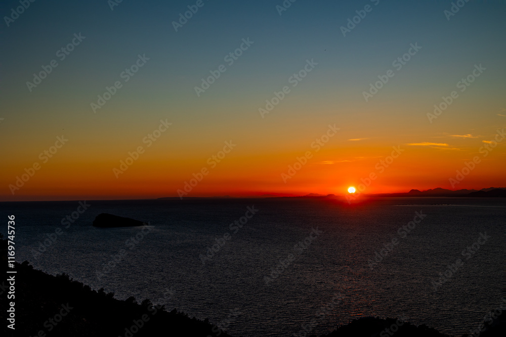 A serene sunset casts a warm orange glow over the horizon A serene sunset casts a warm orange glow over the horizon