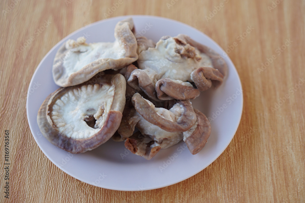 Boiled pork intestines on plate. Concept, street food and weird food that can be cooked for variety delicious menu. Internal organs of pig. Boiled pork intestines on plate. Concept, street food and weird food that can be cooked for variety delicious menu. Internal organs of pig.