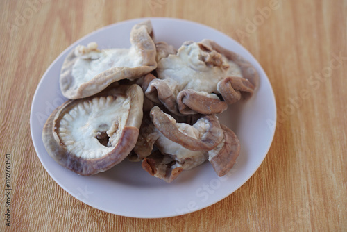 Boiled pork intestines on plate. Concept, street food and weird food that can be cooked for variety delicious menu. Internal organs of pig.   photo