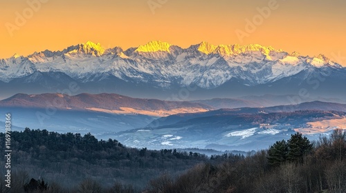 A breathtaking mountain landscape at sunset with snow-capped peaks and rolling hills.