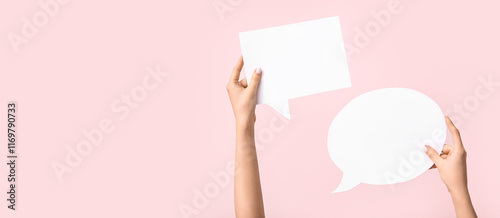 Female hands with blank speech bubbles on pink background