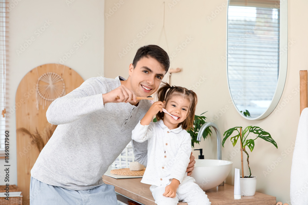 Fototapeta premium Happy father and his cute little daughter brushing teeth in bathroom