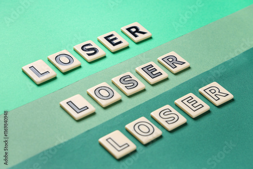 Words LOSER on green background, closeup