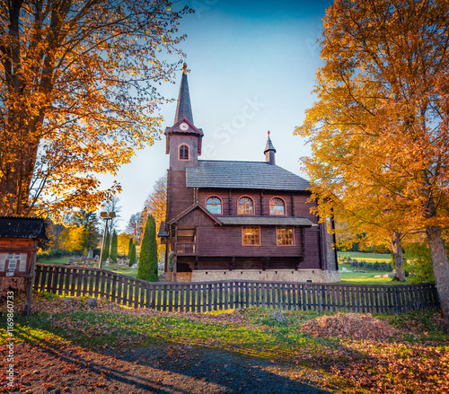 Gorgeous autumn view of wooden St. Anne's Catholic Church. Spectacular evening scene of Javorina village, Slovakia. Wonderful landscape of High Tatras National Park. Traveling concept background. photo