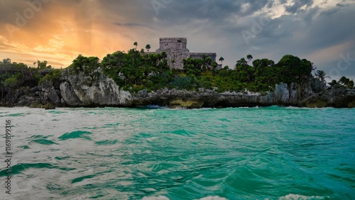 Golden sunset over El Castillo and the UNESCO world heritage monuments and ruins of the 13th century Tulum Mayan Ruins, overlooking the azure waters of the Caribbean Sea in Tulum,Mexico 