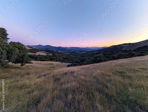 Beautiful landscape with a large hill in the background. The sky is a deep blue color with a pink hue