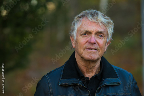 A portrait of an older nordic man outside in the Swedish nature