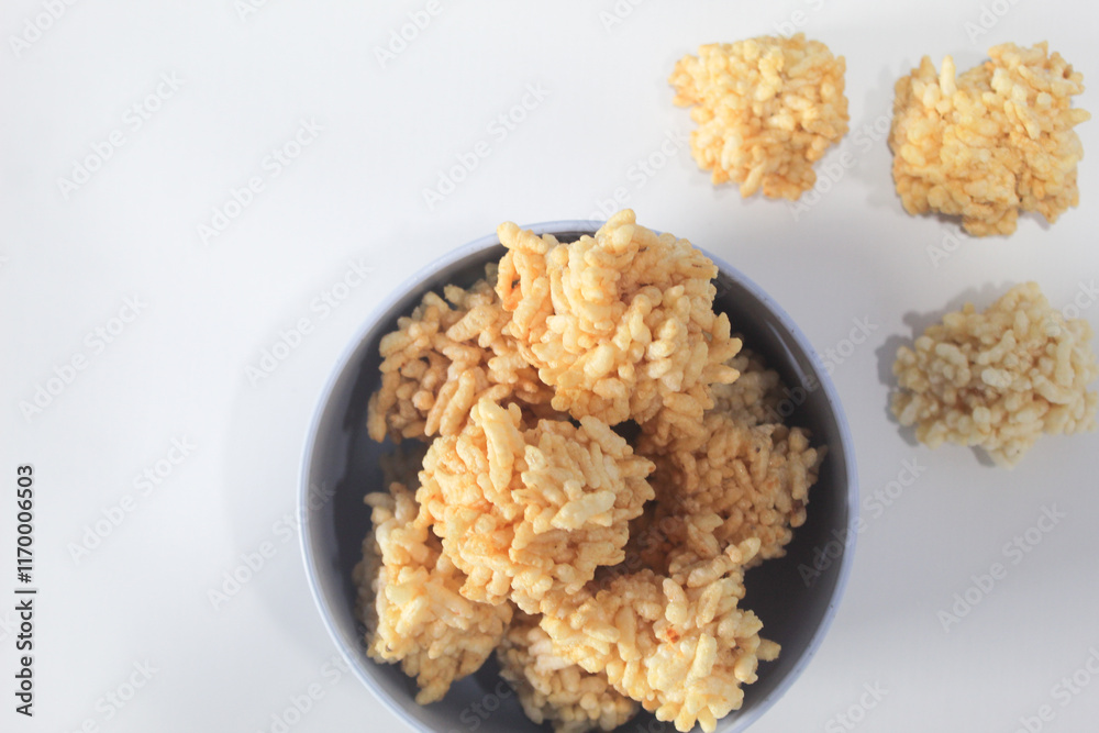 Rengginang or arangginang or rangginang in a small bowl on a white background. Traditional Indonesian snack made from sticky rice and then fried. Rengginang or arangginang or rangginang in a small bowl on a white background. Traditional Indonesian snack made from sticky rice and then fried.