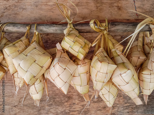 Ketupat or rice dumpling. Most popular food during the festive season. Group of ketupat hanging on wooden pole. photo