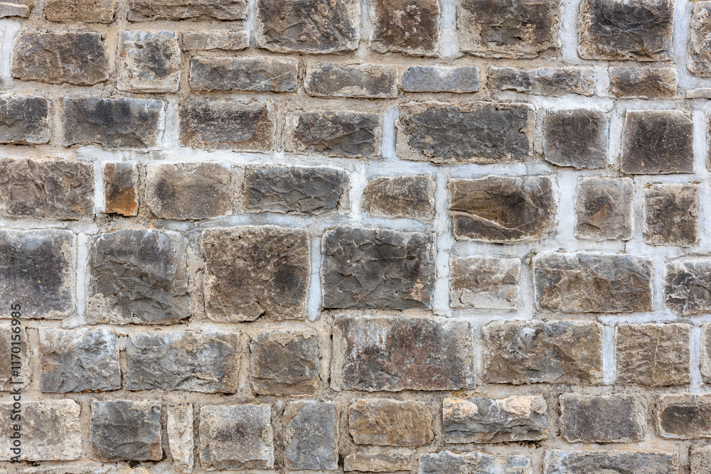 Obraz premium Rugged stone wall texture with rectangular grey and brown bricks