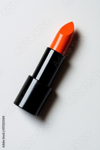 A striking orange lipstick in a black tube, ready to enhance any look.