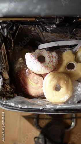 Vertical POV of dumping leftover junkfood and candies into bin