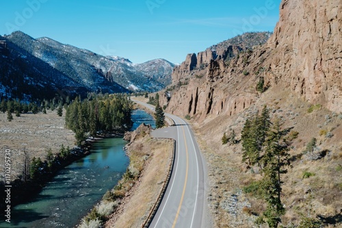 Foto Highway winds through a scenic mountain valley, alongside a river