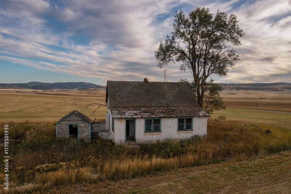 Abandoned farmhouse in a rural landscape. Empty fields and weathered house. Tranquil scene. , Ririe, Idaho, USA. Abandoned farmhouse in a rural landscape. Empty fields and weathered house. Tranquil scene. , Ririe, Idaho, USA.