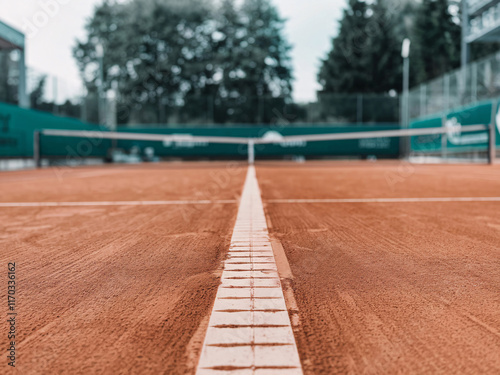 Low angle shot of the t-line of an empty red clay tennis court